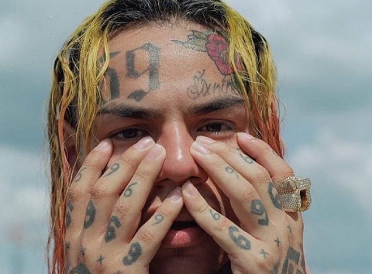 6ix9ine billboard man with hands on his face