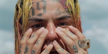 6ix9ine billboard man with hands on his face