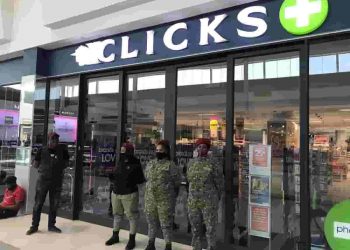 clicks - a group of people standing outside a store