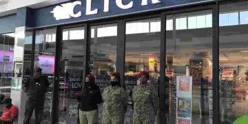 clicks - a group of people standing outside a store